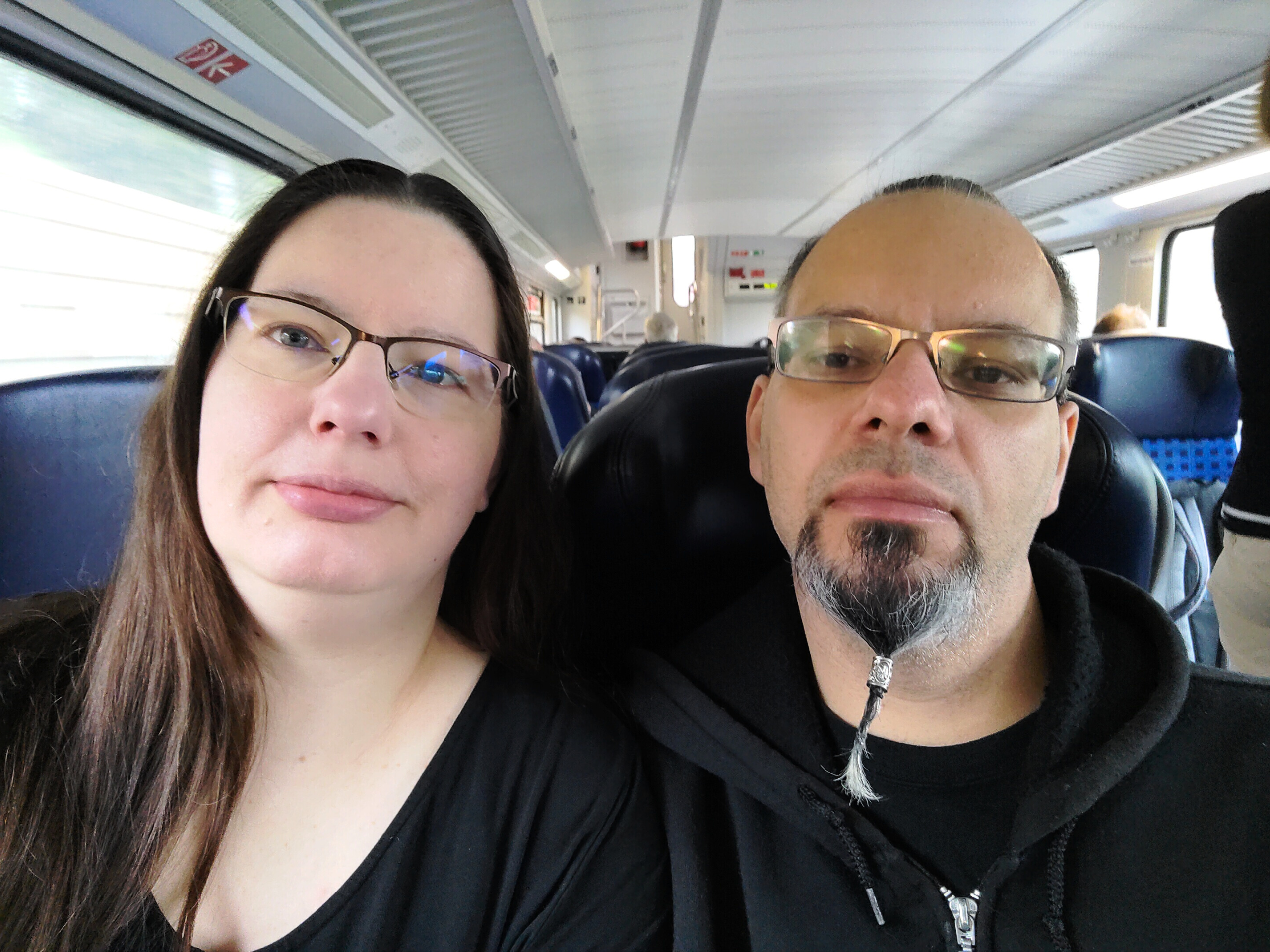 Porträtfoto (Selfie) von Roswitha und Ron, die nebeneinander in einem Zug sitzen.