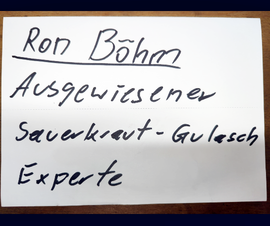 Handgeschriebener Zettel auf dem steht: Ron Böhm. Ausgewiesener Sauerkraut-Gulasch Experte.