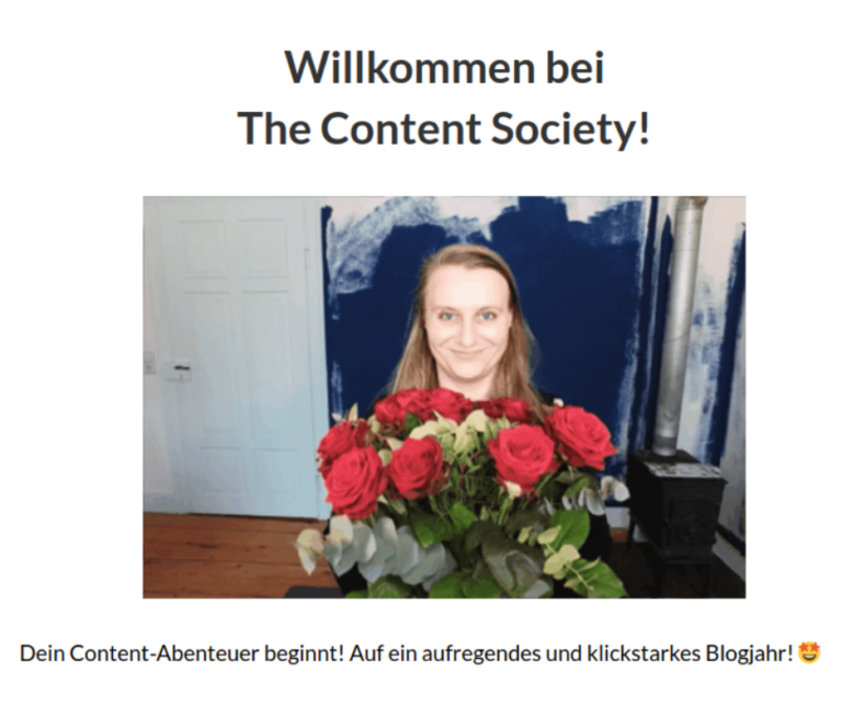 (Screenshot) Ein Foto einer Frau die einen Blumenstrauß roter Rosen in die Kamera zeigt. Es steht dabei: "Willkommen bei The Content Society! Dein Content-Abenteuer beginnt! Auf ein aufregendes und klickstarkes Blogjahr!"