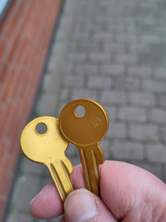 Eine Hand hält zwei goldene Schlüssel.